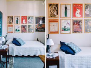 twee bedden in een kamer met foto's aan de muur bij La Casetta Di Filippo E Chiara in Pisa