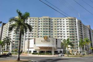 un gran edificio con una palmera delante en Apartamentos Riviera, en Caldas Novas