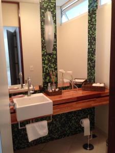 a bathroom with a sink and a mirror at Confortável Casa Condomínio Marbella in Angra dos Reis