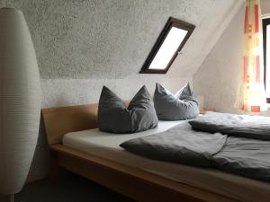 1 dormitorio con 2 camas con almohadas y ventana en Ferienhaus zentral & grün, en Leipzig