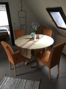 萊比錫的住宿－Ferienhaus zentral & grün，餐桌,椅子和花瓶