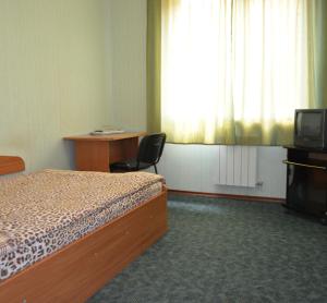 a hotel room with a bed and a desk at Sfinks in Zaporozhye