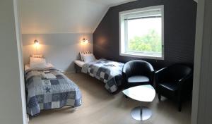 1 Schlafzimmer mit 2 Betten, einem Stuhl und einem Fenster in der Unterkunft Lofoten Bed & Breakfast Reine - Rooms & Apartments in Reine