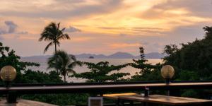 un restaurante con vistas al océano al atardecer en Balcony Party Hostel - Adult Only +18 en Ao Nang