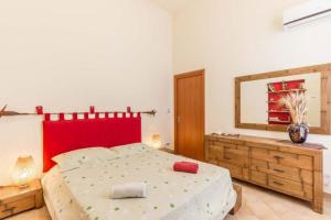 a bedroom with a large bed and a mirror at La Casa di Romi in Marina di Ragusa