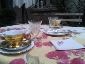 una mesa con una taza y platos y vasos. en B&B La Vagabonde, en Arles 18 fotos más