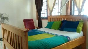 a bedroom with a wooden bed with colorful sheets at Egg Botanical View in Entebbe