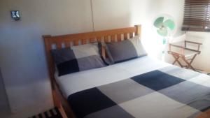 a bedroom with a bed with a blue and white blanket at Egg Botanical View in Entebbe