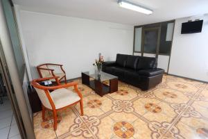 sala de estar con sofá, mesa y sillas en Hotel Pulmahue en Copiapó