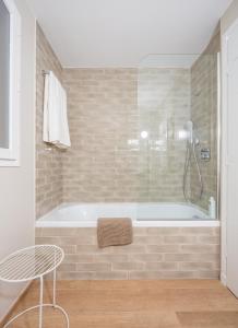 une salle de bain avec une baignoire, une table et une chaise dans l'établissement Studios 10 & 11 BY HOTEL DES LICES, à Saint-Tropez
