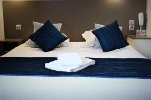 - un lit avec 2 serviettes assises au-dessus dans l'établissement Logis Hotel Le Prieure, à Saint-Marcel