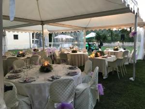 a group of tables in a marquee with white tables and chairs at Villa Oracola in Rieti