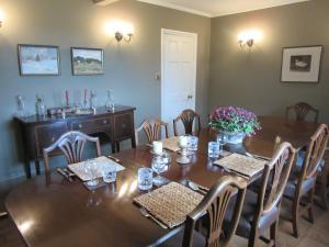 a dining room with a wooden table and chairs at Weston Hill Farm in Moreton Pinkney
