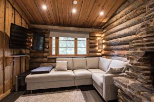 una sala de estar con sofá en una cabaña de madera en UnelmaKelo en Ruka