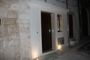 une porte dans un mur en pierre avec des lumières allumées dans l'établissement Liberty Bell, à Ostuni