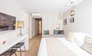 Cette chambre blanche dispose d'un lit et d'un canapé. dans l'établissement Studios 10 & 11 BY HOTEL DES LICES, à Saint-Tropez 10 autres photos