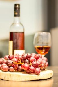 Una copa de vino y un montón de uvas en una mesa. en Carina Villas, en Lourinhã