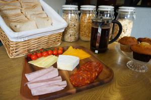 a table with a tray of cheese and meats and bread at Greyfriars Lodge Canterbury in Canterbury