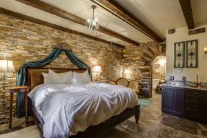 a bedroom with a bed and a brick wall at Storybook Riverside Inn in Leavenworth