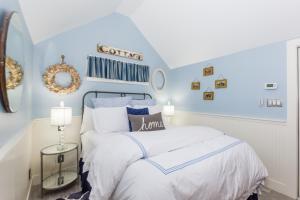 a blue and white bedroom with a bed and a mirror at Agape Cottage in Fredericksburg