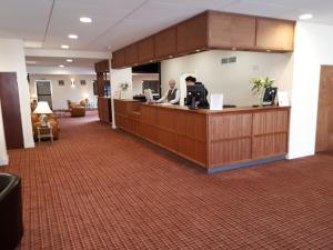 a man sitting at a reception desk in a lobby at Britannia Hotel Aberdeen in Aberdeen