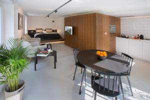 een keuken en een woonkamer met een tafel en stoelen bij Snooz Ap Holiday & Business Flats in Gent