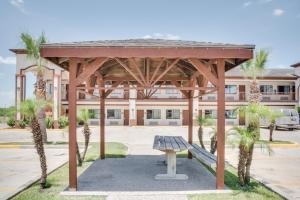 San BenitoLone Star Inn - San Benito Harlingen的楼前设有长凳的木亭 更多4张照片