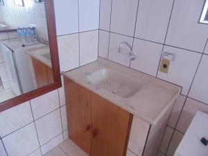 uma casa de banho com um lavatório e um espelho em Chales Marigu em Monte Verde