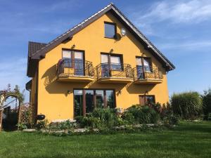 a yellow house with balconies on the side of it at Red Rose in Władysławowo