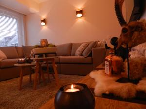 a living room with a couch and a candle on a table at Appartement Sun Corner Deluxe Knokke in Knokke-Heist