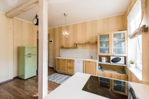 a kitchen with a green refrigerator and wooden cabinets at Reta Apartemendid in Haapsalu