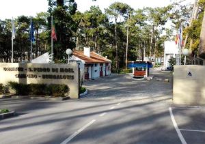 a parking lot with a sign in front of a building at Parque De Campismo Orbitur Sao Pedro De Moel in São Pedro de Moel