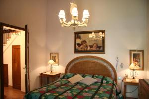 1 dormitorio con cama y lámpara de araña en Casa Grazia, en Gambassi Terme