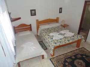 um pequeno quarto com 2 camas e 2 tapetes em Chales Marigu em Monte Verde