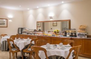a restaurant with tables and a counter with a buffet at Diana Park Hotel in Florence