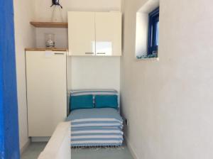 a small room with a bed in the corner of a kitchen at Dimora Tipica Vista Mare in Marettimo