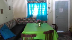 a living room with a green table and a couch at Aike Cabañas de Montaña in San Clemente
