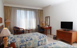 a hotel room with a bed and a flat screen tv at Resor Tuban Tropis in Tuban