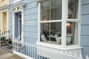 a window on a blue house with a table in it at Lindholme Guest House in Tenby