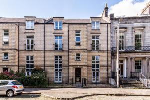 ein großes Backsteingebäude mit einem Auto vor dem Haus in der Unterkunft Luxury City Centre Apartment in Edinburgh