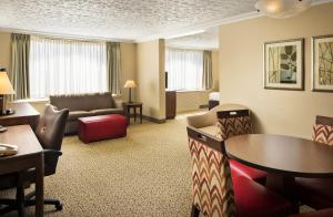 um quarto de hotel com uma área de estar com mesa e cadeiras em Crowne Plaza Louisville Airport Expo Center, an IHG Hotel em Louisville