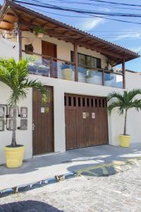 una casa con dos palmeras delante de ella en Pousada Praia e Conforto en Búzios