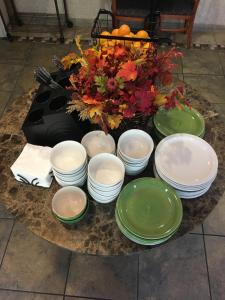 una mesa con platos verdes y blancos y un centro de mesa en Hawthorn Suites by Wyndham Rancho Cordova/Folsom, en Rancho Cordova
