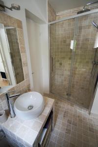 a bathroom with a sink and a glass shower at La Petite Madame in Moret-sur-Loing