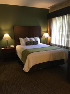 a hotel room with a large bed with two lamps at Hawthorn Suites by Wyndham Rancho Cordova/Folsom in Rancho Cordova