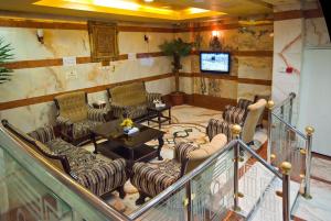 a lobby with chairs and a table and a television at Diyar Taiba Hotel in Medina