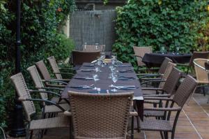 einen langen Tisch mit Stühlen und Weingläsern in der Unterkunft L'Argolla Hotel-Pizzeria in Santa Coloma de Farners