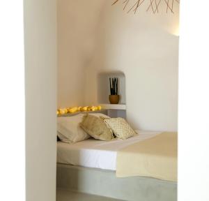 a bedroom with white walls and a bed with pillows at Delta Suites in Oia
