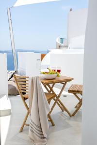 a table and chairs with a bowl of fruit on it at Delta Suites in Oia