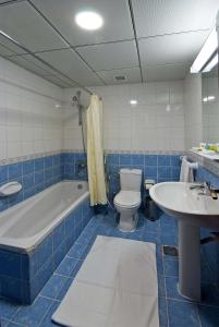 a bathroom with a tub and a toilet and a sink at Diyar Al Nakheel Hotel in Medina